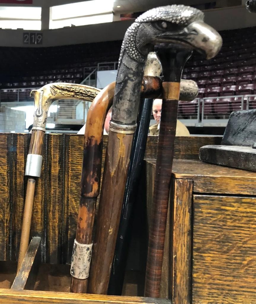 Antique walking sticks and canes including one with a silver bald eagle head handle displayed in a wooden box