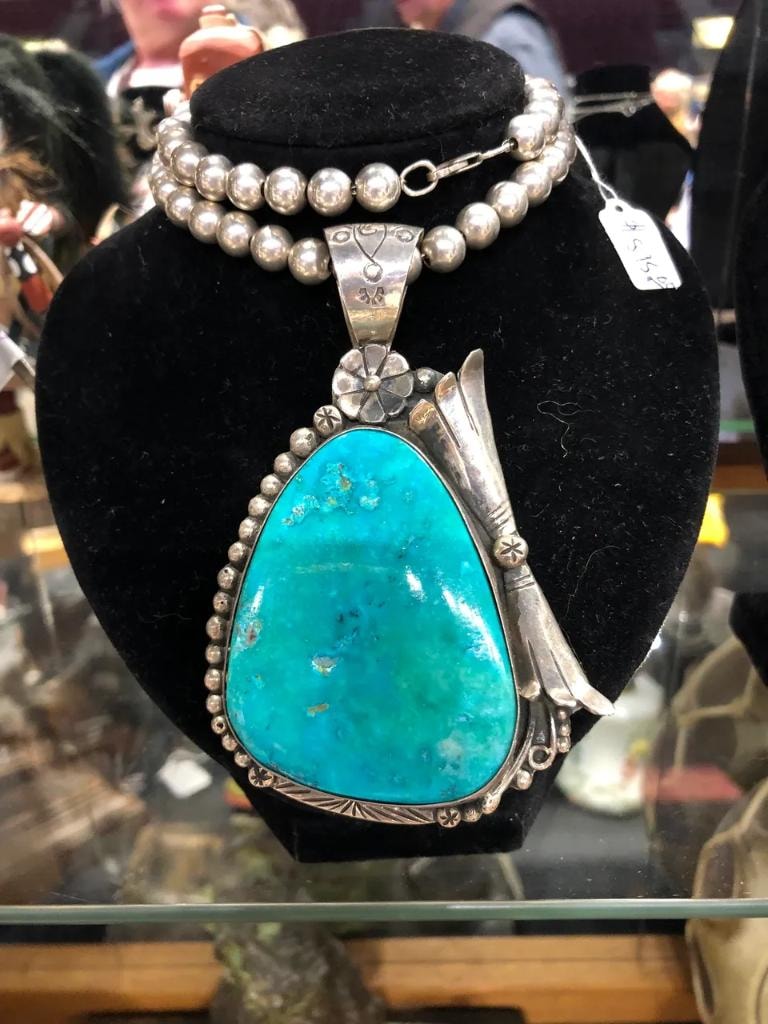 Large Native American turquoise and silver pendant necklace on a black velvet bust display