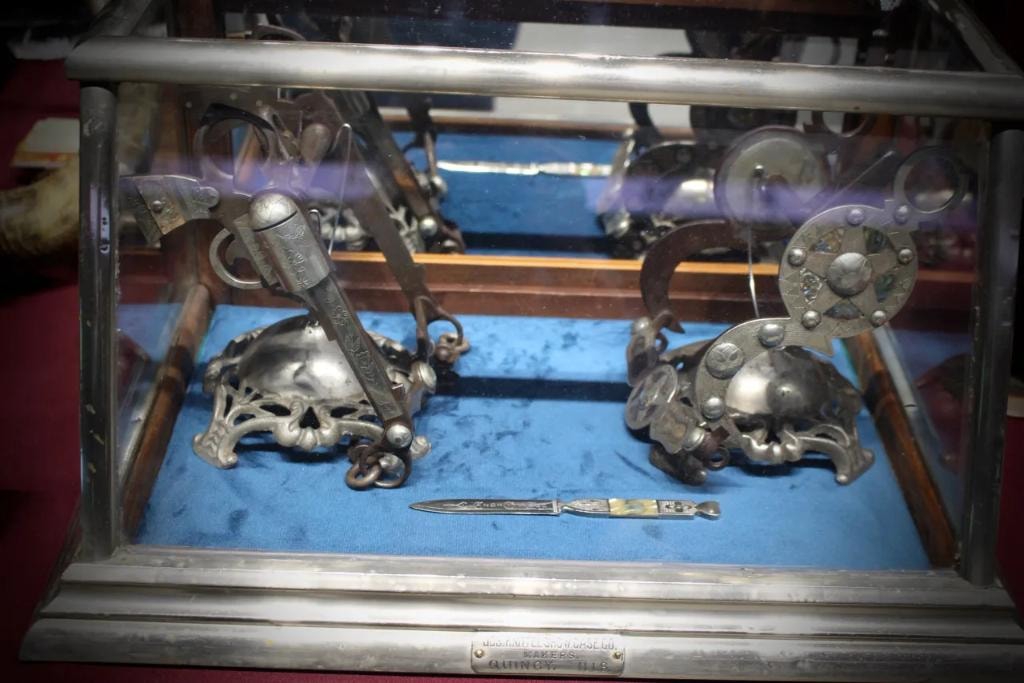 Antique western spurs and collectibles in a glass display case