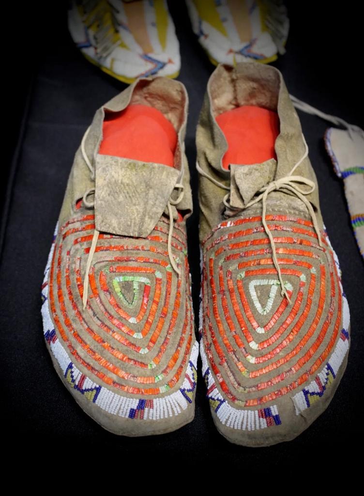 Pair of Native American moccasins with orange and white geometric beadwork