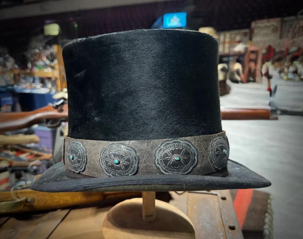 Black top hat with silver concho and turquoise hat band