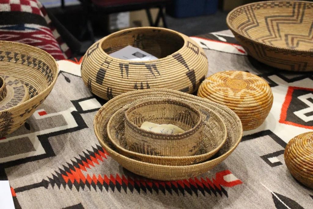 Coiled Native American baskets displayed on Navajo rug