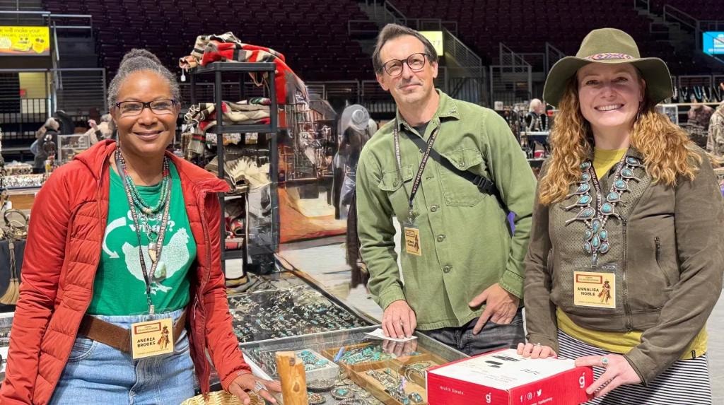 Three exhibitors wearing CCG lanyards at jewelry vendor booth