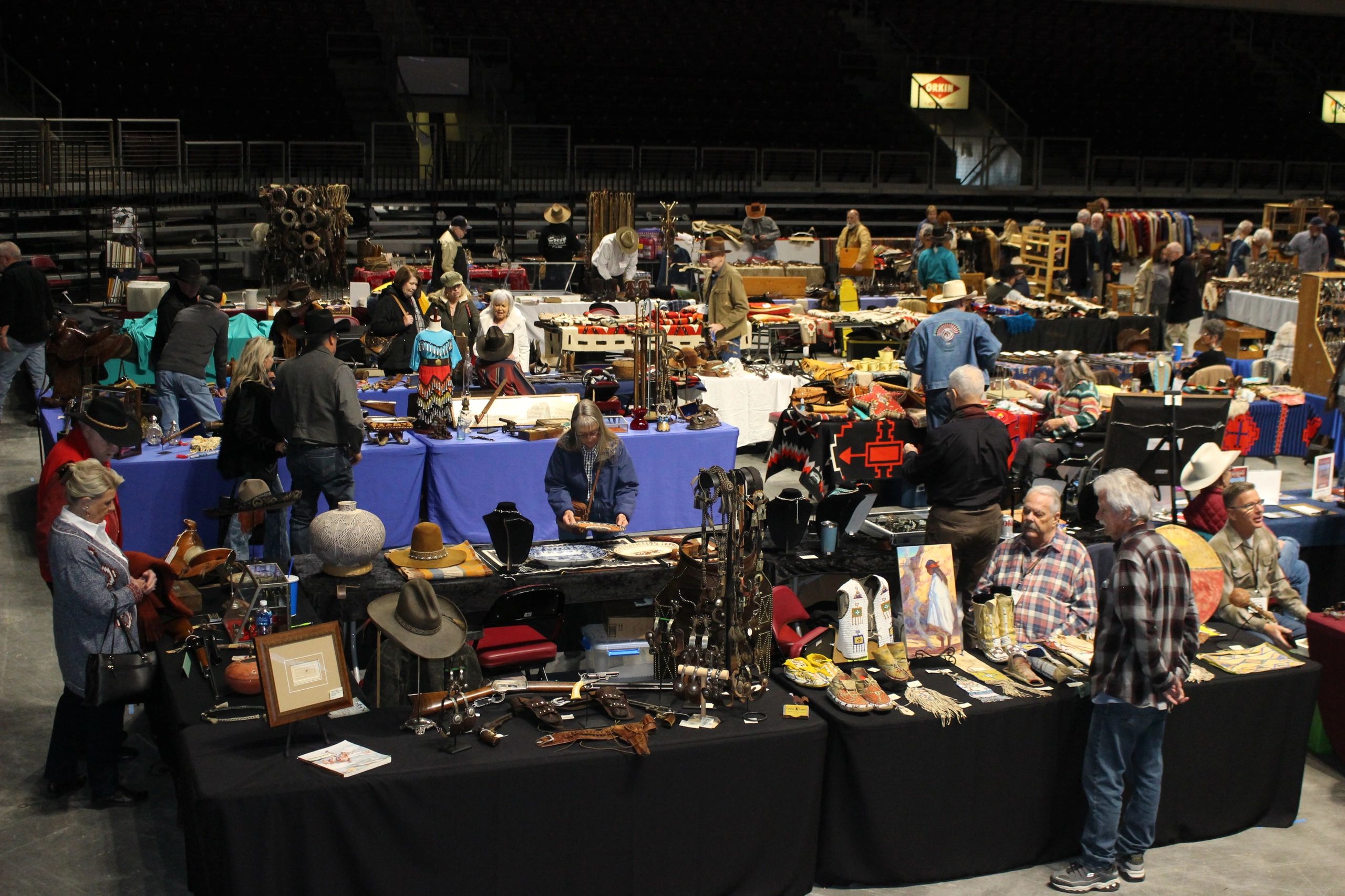 Indoor western collectibles trade show crowd at arena